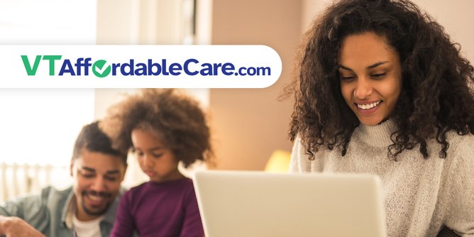 Woman looking at computer with family in background